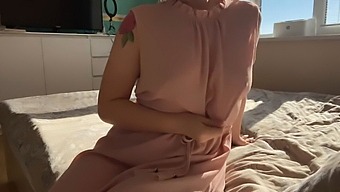 A Woman In A Soft Pink Dress Explores Her Sensuality